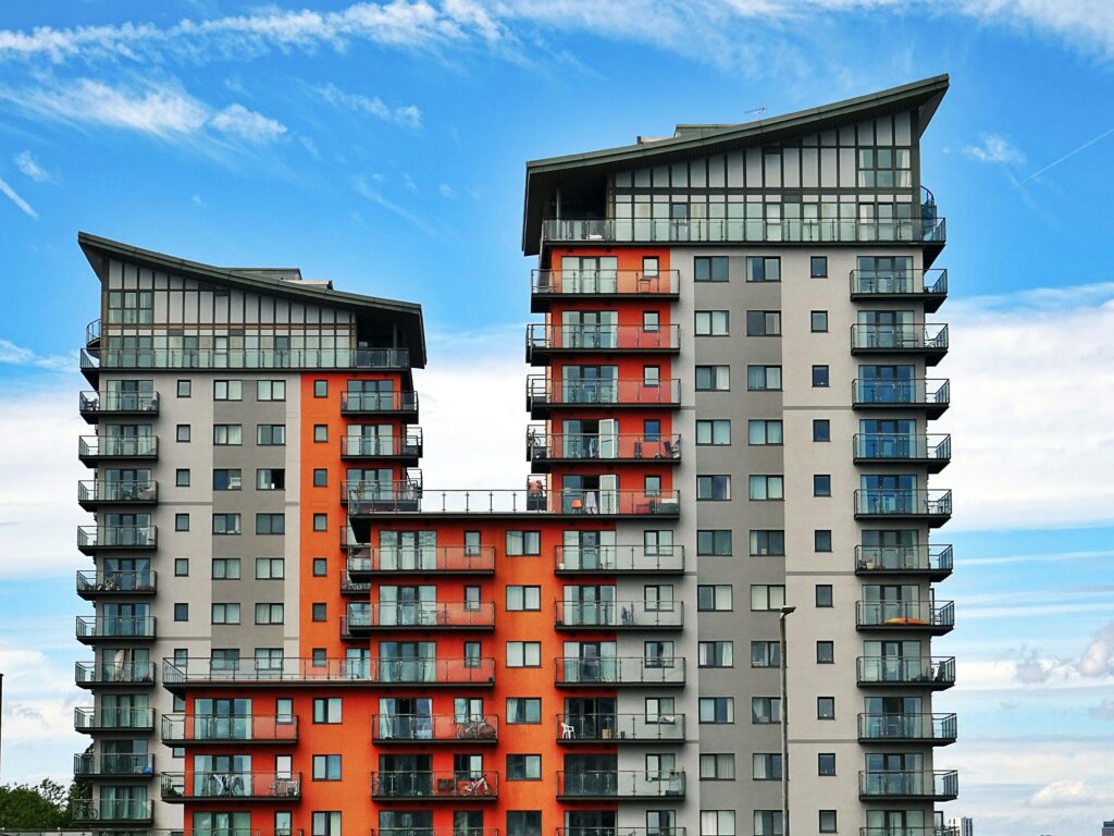 pexels-photo-439391-439391 Modern high-rise apartment buildings with unique architecture under a vibrant blue sky.