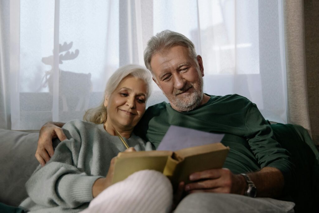 pexels-photo-6158658-6158658 An elderly couple sharing a joyful moment while reading together at home.